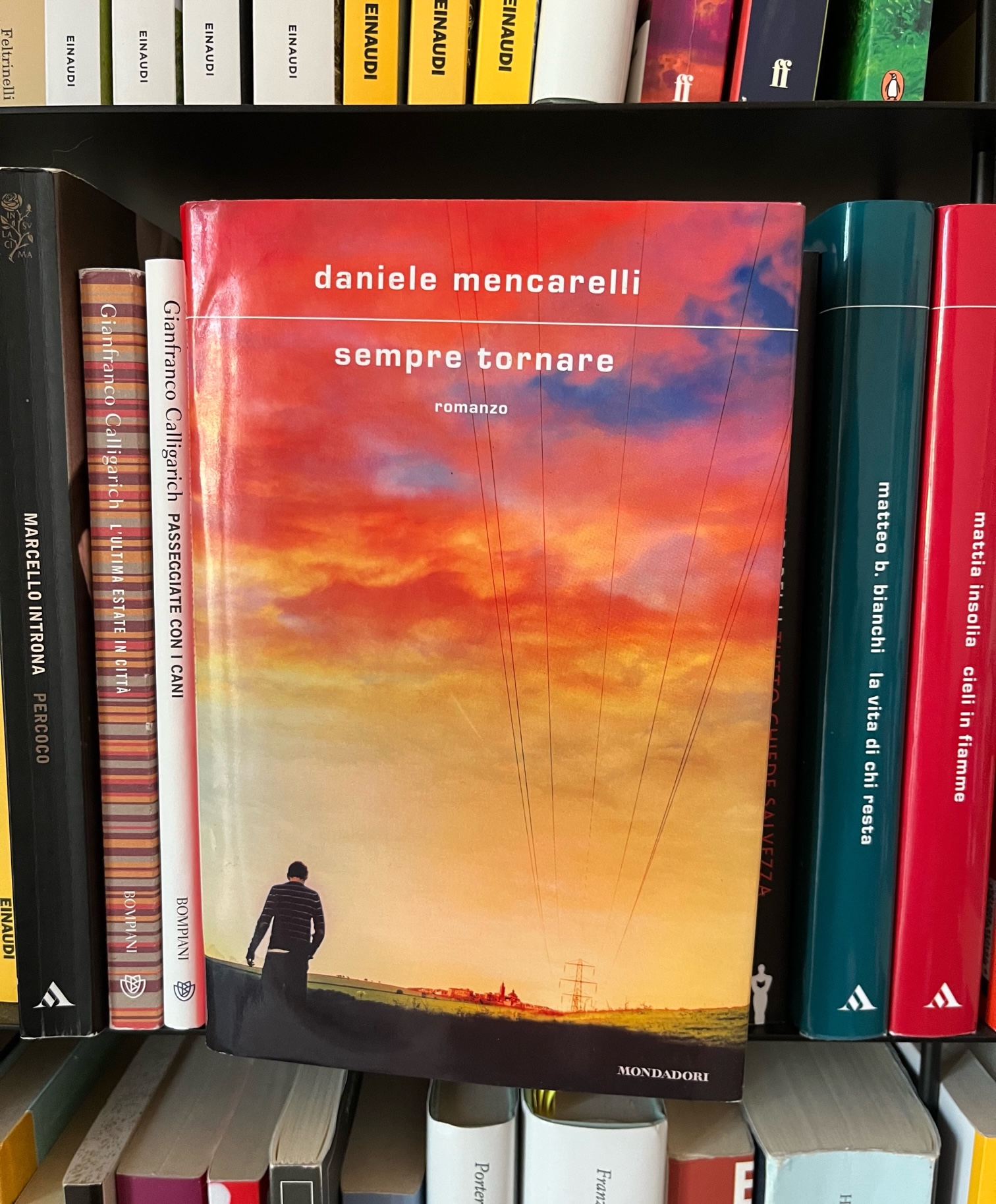 Copertina del romanzo di Daniele Mencarelli "Sempre tornare". Un uomo cammina su una strada alal luce del tramonto.