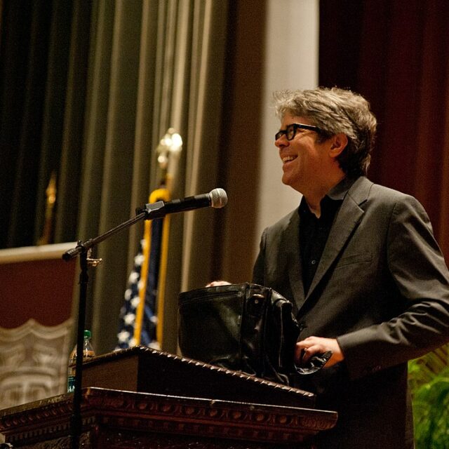 Jonathan Franze sorride da un palco durante un suo intervento pubblico