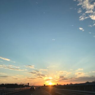 tramonto arancio su una strada statale visto da un'auto