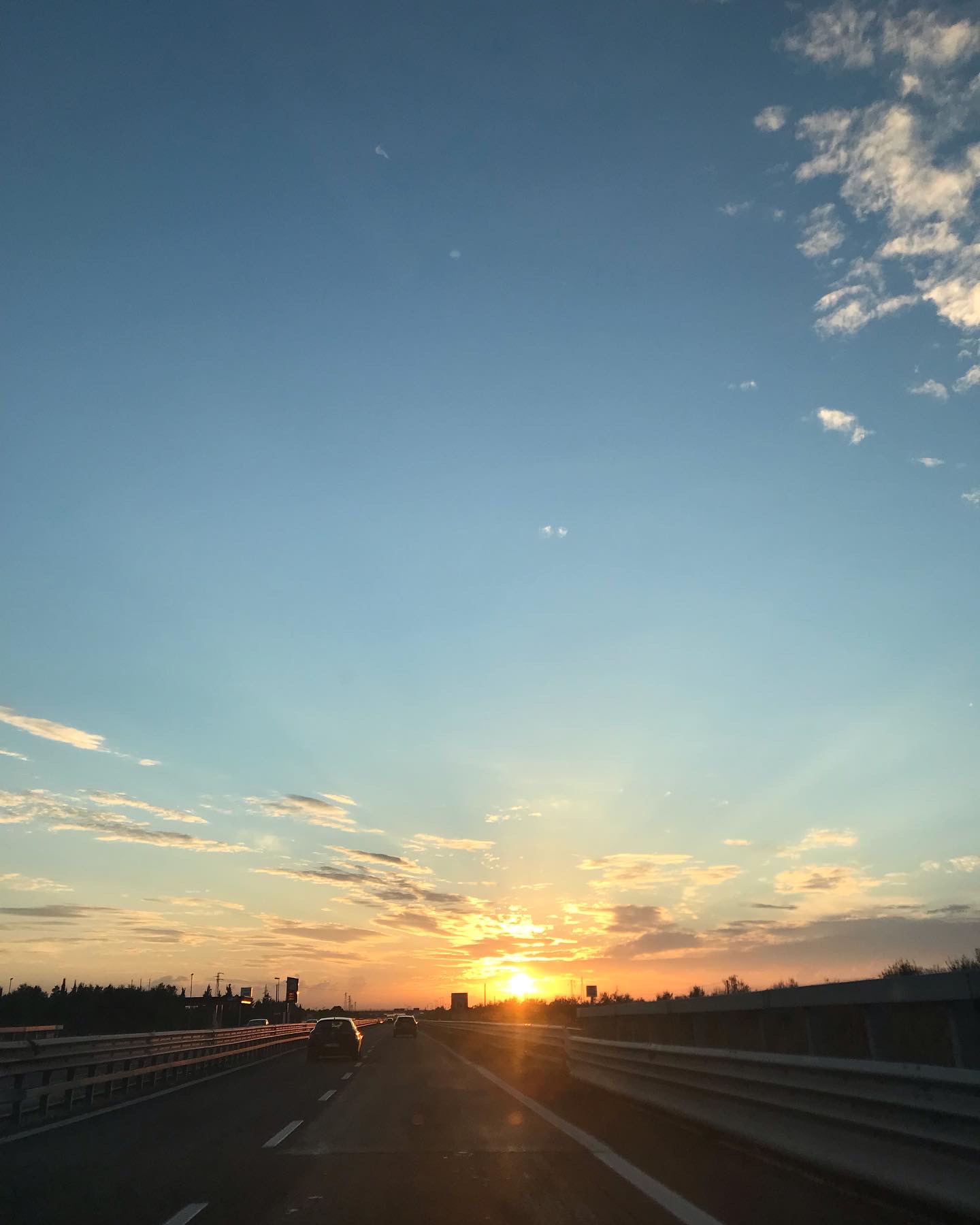 tramonto arancio su una strada statale visto da un'auto